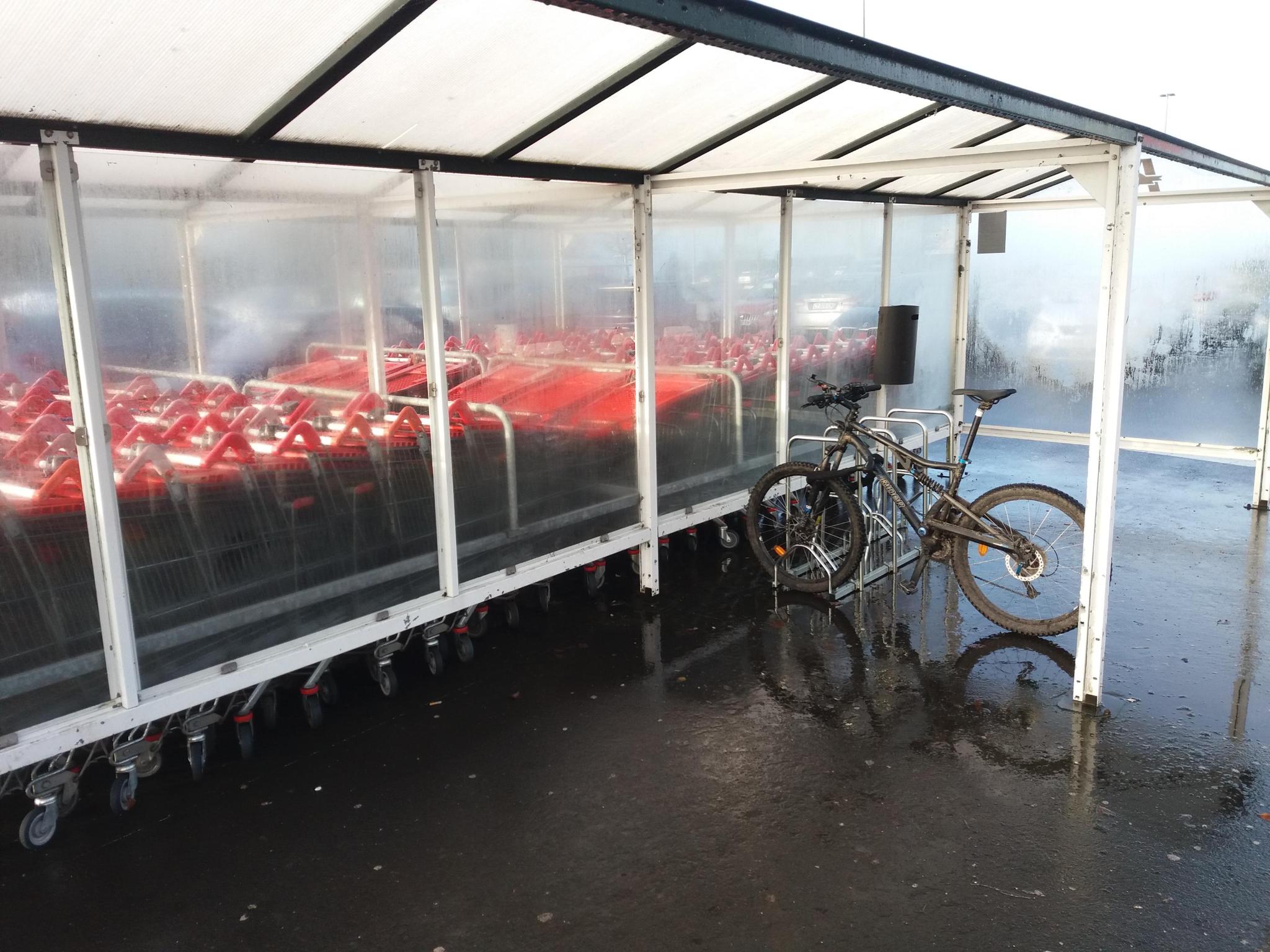 Abri vélo avec un vélo garé et des arceaux bien adaptés